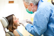 Dentist curing a female patient
