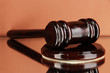 Wooden gavel on brown background