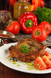 Piece of fried meat on plate on wooden table on fire background