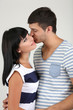 Beautiful loving couple kissing on grey background