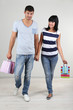 Beautiful loving couple is shopping on grey background