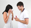 Man makes woman offer get engaged on grey background