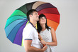 Beautiful loving couple with umbrella on grey background