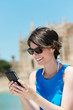 Photo: lächelnde touristin schaut auf ihr handy lächelnde touristin schaut auf ihr handy