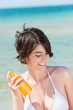 schöne frau am meer trägt sonnencreme auf