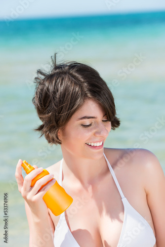 Photo: schöne frau am meer trägt sonnencreme auf schöne frau am meer trägt sonnencreme auf