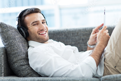 Photo: Man on sofa with digital tablet Man on sofa with digital tablet