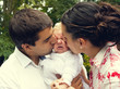 Parents kissing their crying baby