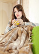 Foto: Girl on sofa with cup of tea Girl on sofa with cup of tea