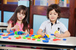 Children Playing With Construction Blocks At Desk