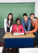 Teacher With Teenage Students At Desk In Classroom