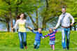 Foto: Happy family running on summer meadow Happy family running on summer meadow