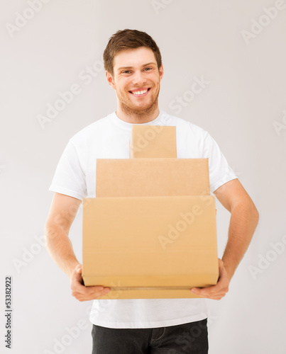Photo: smiling man carrying carton boxes smiling man carrying carton boxes