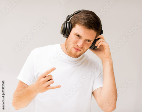 Photo: man with headphones listening rock music man with headphones listening rock music