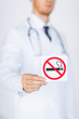 Photo: male doctor holding no smoking sign male doctor holding no smoking sign