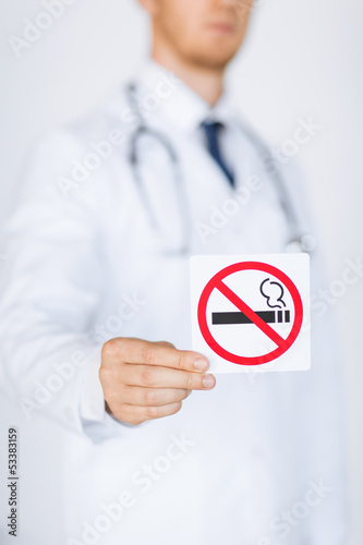 Photo: male doctor holding no smoking sign male doctor holding no smoking sign