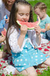 Photo: Pretty little girl eating watermelon in the park Pretty little girl eating watermelon in the park