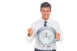 Fearful businessman holding and looking at clock