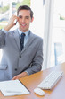 Smiling businessman on the phone looking at camera