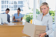 Businesswoman leaving office after being laid off and looking at