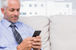 Cheerful businessman using smartphone