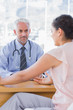 Foto: Female patient explaining her painful to doctor Female patient explaining her painful to doctor