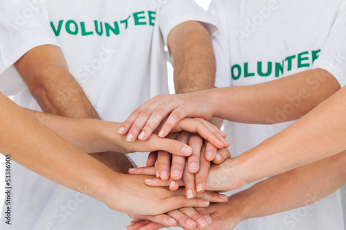 Photo: Volunteers piling up their hands together Volunteers piling up their hands together