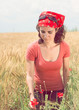 Beautiful young woman picking a poppy