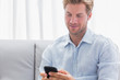 Man using his phone on a couch
