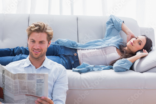Photo: Woman relaxing on a couch listening to music Woman relaxing on a couch listening to music