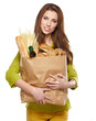 Young woman holding a grocery bag full of bread
