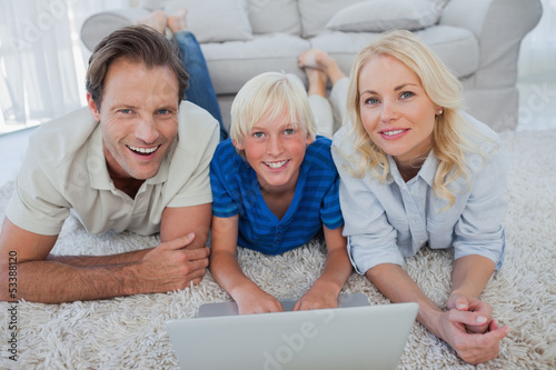 Photo: Portrait of son and parents using a laptop Portrait of son and parents using a laptop