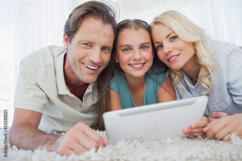 Photo: Portrait of a girl and her parents using a tablet Portrait of a girl and her parents using a tablet