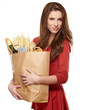 Young woman holding a grocery bag full of bread