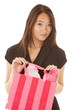 Photo: woman holds up pink shopping bag serious woman holds up pink shopping bag serious