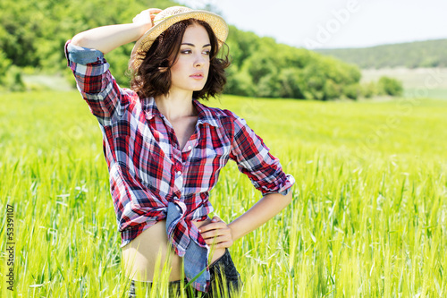 Photo: Beautiful woman in hat on summer meadow Beautiful woman in hat on summer meadow
