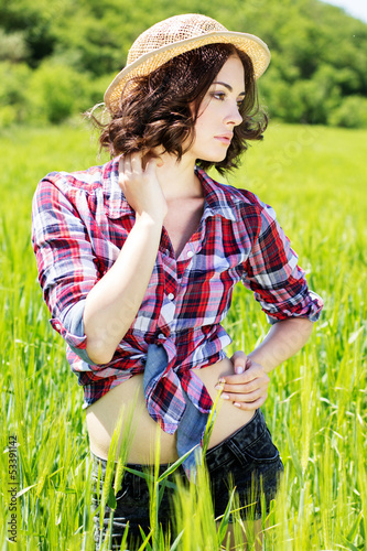 Photo: Beautiful woman in hat on summer meadow Beautiful woman in hat on summer meadow