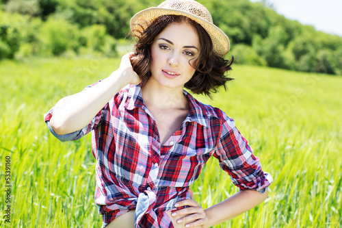 Photo: Beautiful woman in hat on summer meadow Beautiful woman in hat on summer meadow