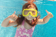 Photo: The little girl swimming underwater and smiling The little girl swimming underwater and smiling