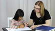 Homeschool Teacher Teaching Writing Lesson To Daughter