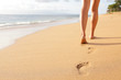 Beach travel - woman walking on sand beach closeup Beach travel - woman walking on sand beach closeup
