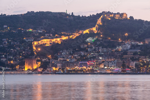 Photo: Beautiful evening view of wall of an old castle in light Beautiful evening view of wall of an old castle in light