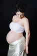 Studio portrait of pregnant woman on dark background