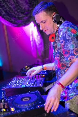 Photo: Profile portrait DJ mixes the records at the club Profile portrait DJ mixes the records at the club