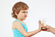 Little cute blonde boy refuses drink a fresh milk