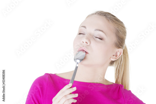 Photo: Portrait of young smiling woman with spoon in her mouth. Portrait of young smiling woman with spoon in her mouth.