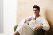 Young man in robe relaxing in health spa