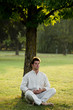 Young man meditating under a tree