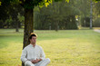 Young man meditating under a tree
