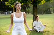 Young couple meditating in park